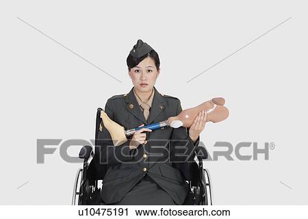 Female US military officer in wheelchair holding artificial limb over gray backgrounds View Large Photo Image Stock Image - Female US military officer in wheelchair holding artificial limb over gray backgrounds. Fotosearch