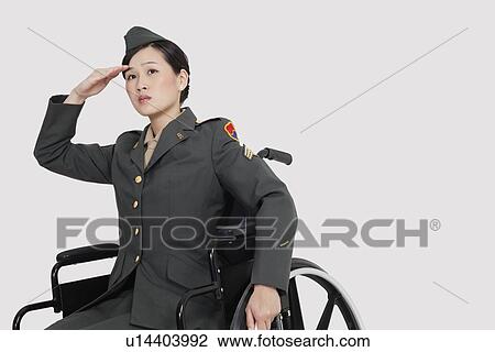 Stock Image - Female US military officer in wheelchair saluting over gray backgrounds. Fotosearch