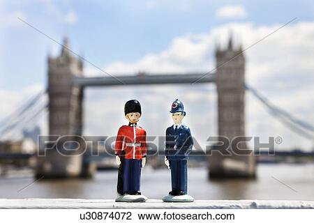 Stock Image - Figurines of police officer and coldstream guard with London Bridge in background. Fotosearch