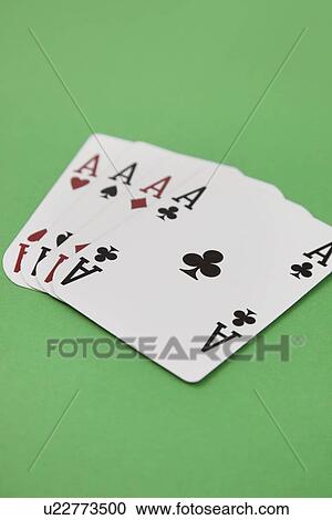 Stock Image - Four aces playing cards over green surface. Fotosearch