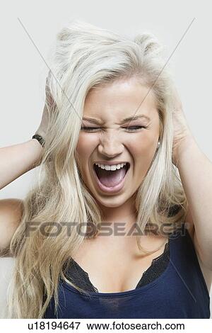 Frustrated woman with hands in hair over gray background View Large Photo Image Stock Photo - Frustrated woman with hands in hair over gray background. Fotosearch