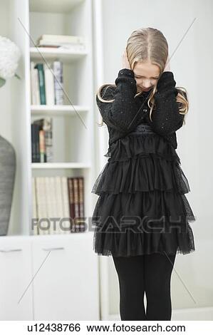 Stock Photograph - Frustrated young girl covering ears. Fotosearch
