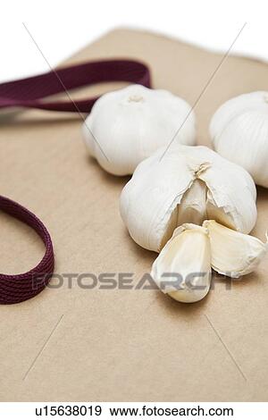 Stock Photo - Garlic with separated pieces on wooden chopping board. Fotosearch