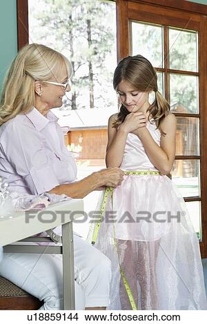 Grandmother measuring granddaughter's waist with tape View Large Photo Image Picture - Grandmother measuring granddaughter's waist with tape. Fotosearch