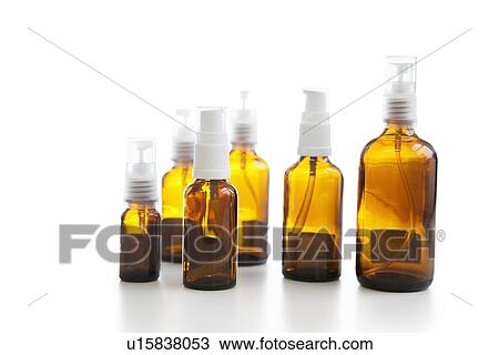 Stock Image - Group of empty glass spray bottles over white background. Fotosearch