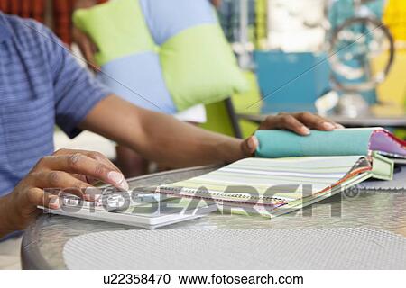 Hands of male salesperson calculating expenses with swatch on table View Large Photo Image Stock Image - Hands of male salesperson calculating expenses with swatch on table. Fotosearch