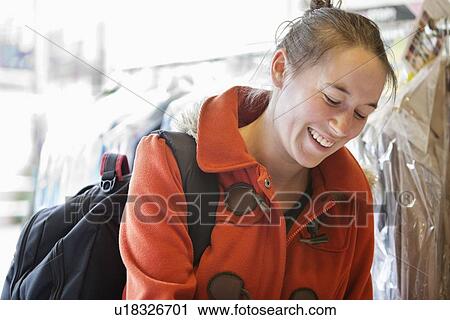 Stock Image - Happy young woman at laundry. Fotosearch