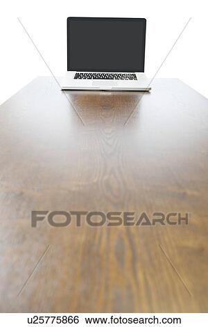 Stock Photograph - Laptop at the end of wooden table. Fotosearch