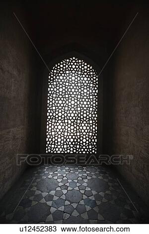 Stock Image - Light coming through stone lattice at Humayun's Tomb, New Delhi, India. Fotosearch