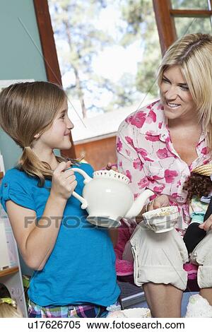 Little girl pretending to pour tea for her mother View Large Photo Image Stock Photography - Little girl pretending to pour tea for her mother. Fotosearch