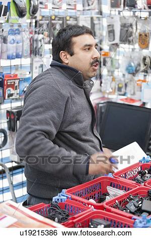 Male sales clerk working in electronics store View Large Photo Image Stock Photograph - Male sales clerk working in electronics store. Fotosearch