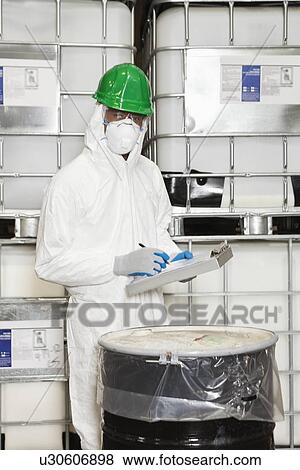 Male technician in hazmat suit taking down notes of chemical in drum View Large Photo Image Stock Photo - Male technician in hazmat suit taking down notes of chemical in drum. Fotosearch