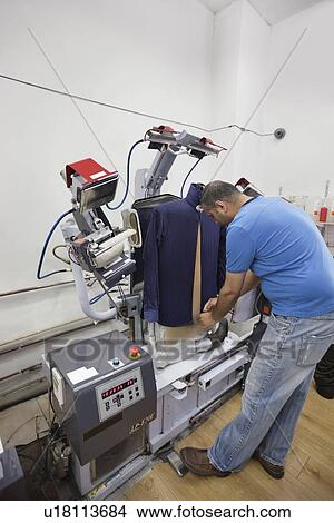 Man adjusting shirt on laundry dummy machine at launderette View Large Photo Image Picture - Man adjusting shirt on laundry dummy machine at launderette. Fotosearch