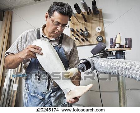 Mature male worker buffing prosthetic limb View Large Photo Image Picture - Mature male worker buffing prosthetic limb. Fotosearch