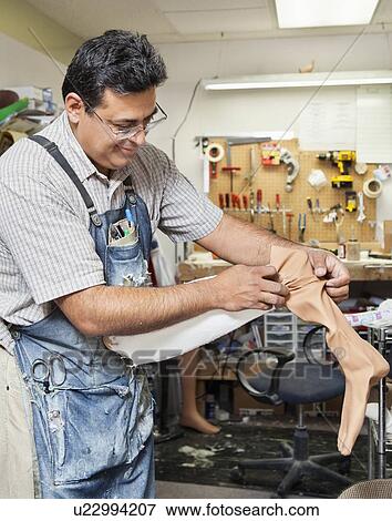 Mature male worker working on prosthetic limb View Large Photo Image Stock Photo - Mature male worker working on prosthetic limb. Fotosearch