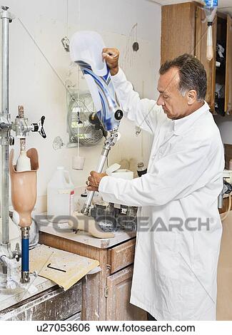 Stock Photograph - Mature technician working on prosthetic foot. Fotosearch
