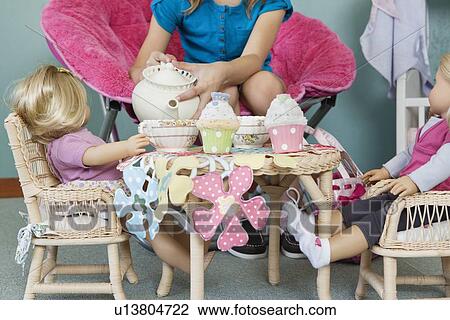 Midsection of girl pretending to have tea party with her dolls View Large Photo Image Stock Image - Midsection of girl pretending to have tea party with her dolls. Fotosearch