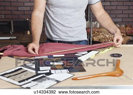 Midsection of male fashion designer taking measurement of shirt View Large Photo Image Stock Image - Midsection of male fashion designer taking measurement of shirt. Fotosearch