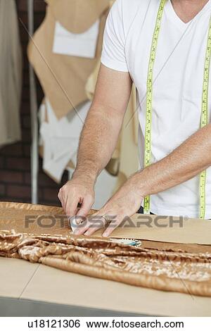 Midsection of male tailor marking pattern with chalk on fabric View Large Photo Image Stock Photograph - Midsection of male tailor marking pattern with chalk on fabric. Fotosearch