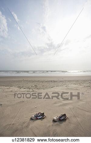 Pair of canvas shoes lying on shore at Vagator beach, Goa, India View Large Photo Image Stock Photo - Pair of canvas shoes lying on shore at Vagator beach, Goa, India. Fotosearch