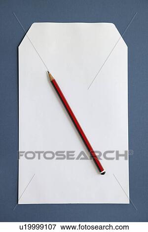 Stock Photo - Pencil and blank paper over dark blue surface. Fotosearch