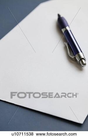 Stock Photo - Pencil on a blank paper on dark blue surface. Fotosearch
