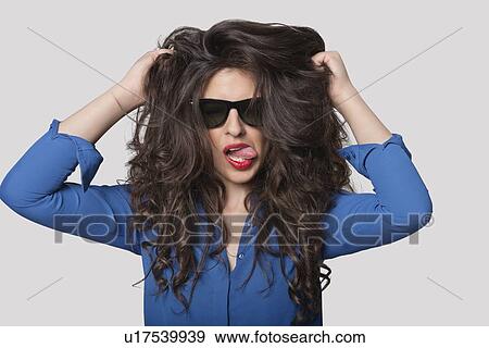 Portrait of a flirtatious young woman over gray background View Large Photo Image Stock Photo - Portrait of a flirtatious young woman over gray background. Fotosearch