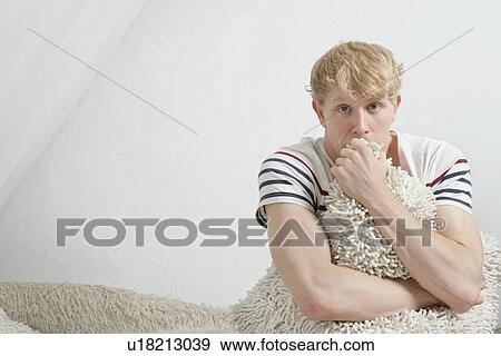 Portrait of a scared young man hugging fur blanket View Large Photo Image Stock Photo - Portrait of a scared young man hugging fur blanket. Fotosearch