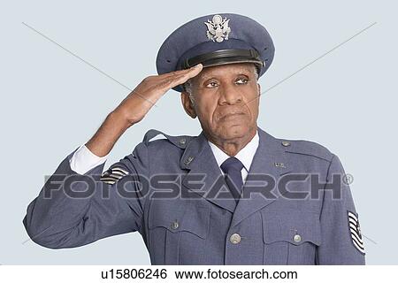 Stock Photograph - Portrait of a senior male US Air Force officer saluting over light blue background. Fotosearch