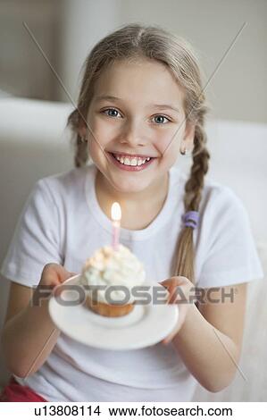 Portrait of a young girl with cupcake View Large Photo Image Picture - Portrait of a young girl with cupcake. Fotosearch