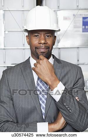 Portrait of an African American male contractor standing with hand on chin View Large Photo Image Stock Photography - Portrait of an African American male contractor standing with hand on chin. Fotosearch