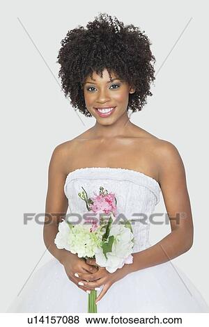 Portrait of an attractive African American bride holding bouquet over gray background View Large Photo Image Stock Photo - Portrait of an attractive African American bride holding bouquet over gray background. Fotosearch