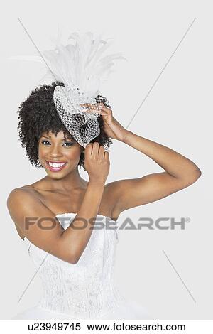 Portrait of beautiful African American bride wearing feather fascinator over gray background View Large Photo Image Stock Photography - Portrait of beautiful African American bride wearing feather fascinator over gray background. Fotosearch