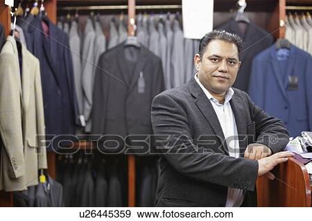 Stock Photo - Portrait of businessman standing in menswear store. Fotosearch