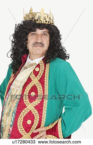 Stock Image - Portrait of confident senior king with royal crown on head over gray background. Fotosearch