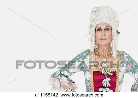Stock Image - Portrait of confident senior queen against gray background. Fotosearch