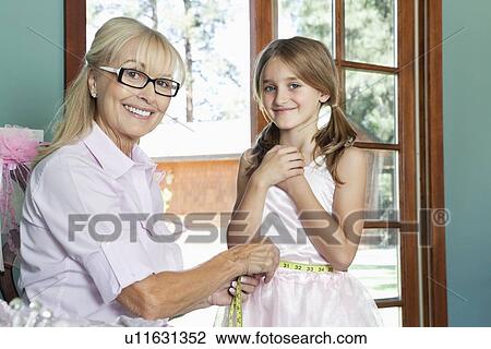 Portrait of grandmother measuring granddaughter's waist with tape View Large Photo Image Stock Image - Portrait of grandmother measuring granddaughter's waist with tape. Fotosearch