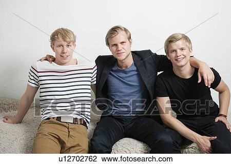 Portrait of happy male friends sitting together View Large Photo Image Stock Image - Portrait of happy male friends sitting together. Fotosearch