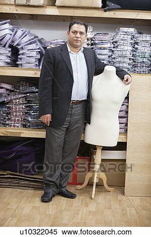 Portrait of male owner standing by tailor's dummy in clothing store View Large Photo Image Stock Photography - Portrait of male owner standing by tailor's dummy in clothing store. Fotosearch