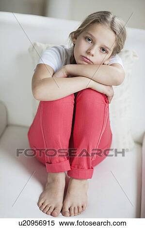 Portrait of sad girl sitting on sofa View Large Photo Image Stock Photography - Portrait of sad girl sitting on sofa. Fotosearch