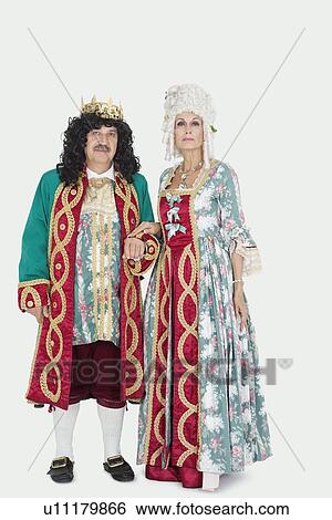 Stock Photograph - Portrait of senior couple as king and queen over gray background. Fotosearch