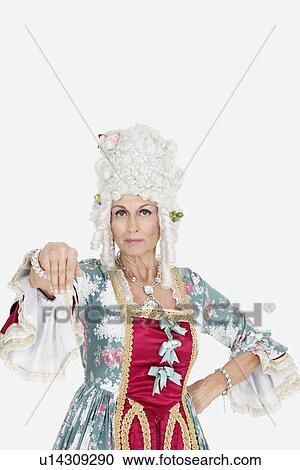 Stock Image - Portrait of serious senior queen gesturing over gray background. Fotosearch