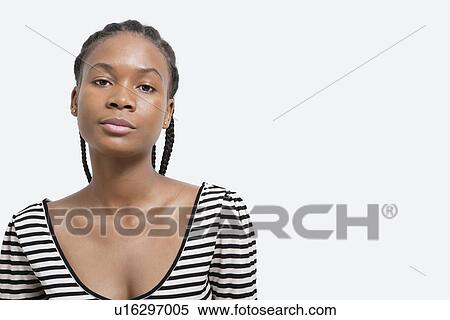 Portrait of serious young woman against gray background View Large Photo Image Stock Photography - Portrait of serious young woman against gray background. Fotosearch