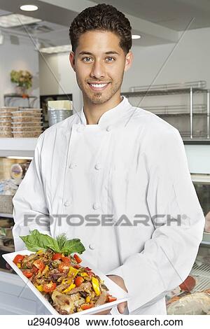 Portrait of young male chef holding chicken salad in serving dish View Large Photo Image Stock Photo - Portrait of young male chef holding chicken salad in serving dish. Fotosearch
