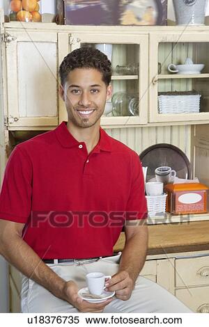 Portrait of young man smiling while having tea View Large Photo Image Stock Photography - Portrait of young man smiling while having tea. Fotosearch