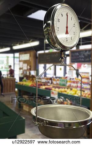 Stock Photo - Produce scale in supermarket with people in background. Fotosearch