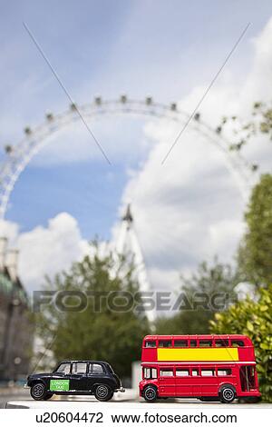 Stock Image - Public transport figurines with London Eye in the background. Fotosearch