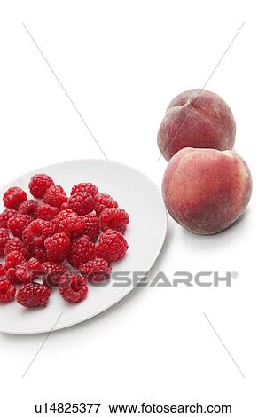 Raspberries in plate with peaches over white background View Large Photo Image Stock Photo - Raspberries in plate with peaches over white background. Fotosearch