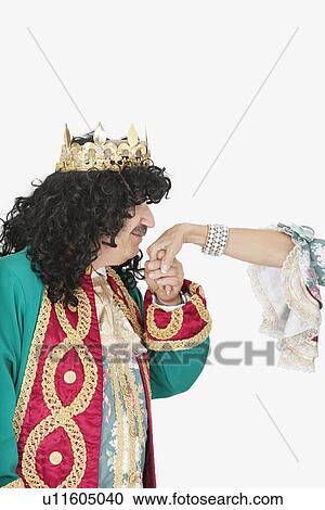 Stock Image - Senior king kissing the hand of queen over gray background. Fotosearch