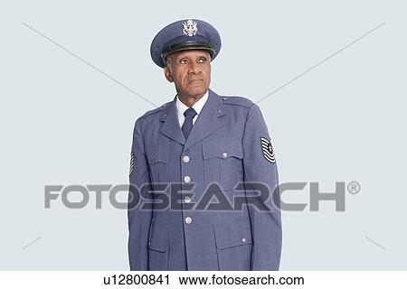 Stock Image - Senior male US Air Force officer standing over light blue background. Fotosearch
